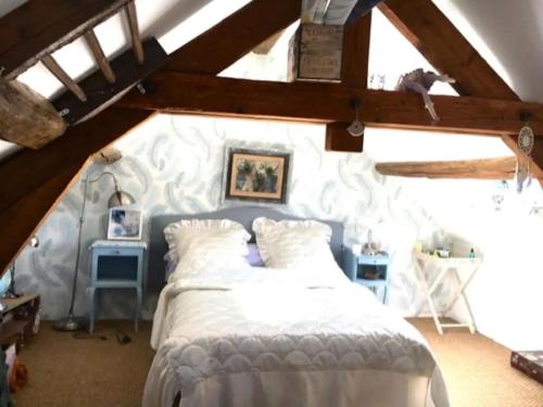 sypialnia z białym łóżkiem na poddaszu w obiekcie Romantic holiday home in Précy with garden w mieście Précy