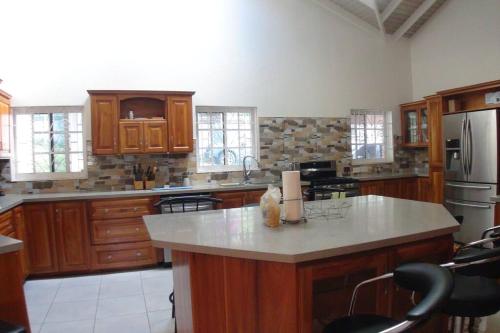 a large kitchen with wooden cabinets and a large island at Paradise Getaway in Calivigny
