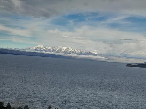 a large body of water with mountains in the background at Sol y Luna - ISLA DEL SOL in Comunidad Yumani
