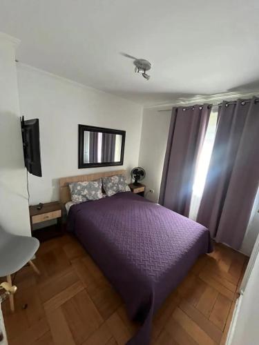 - une chambre avec un lit violet et une télévision dans l'établissement Habitacion de casa en Las Condes, à Santiago