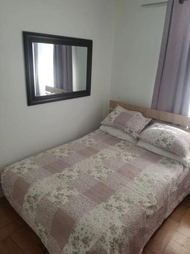a bed in a bedroom with a mirror on the wall at Habitacion de casa en Las Condes in Santiago