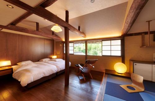 a bedroom with a large bed in a room with wooden ceilings at PAYSAGE MORIGUCHI in Mima