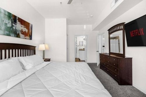 a bedroom with a large bed with a dresser and a mirror at Home away from home near Disney! in Kissimmee