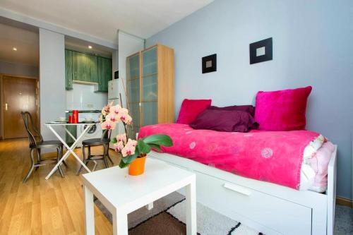 1 dormitorio con cama rosa y mesa en One bedroom property with wifi at Madrid, en Madrid