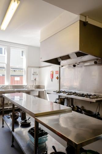 a large kitchen with tables in a kitchen at Haka House Christchurch in Christchurch