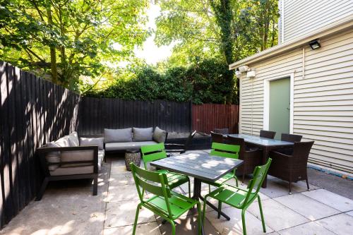 a patio with a table and chairs and a couch at Haka House Christchurch in Christchurch