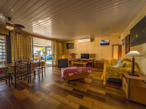 a living room with a couch and a table at TAHITI - Bungalow Taharuu Surf Piti in Papara