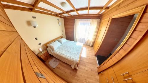a small bedroom with a bed in a wooden house at Habitación con Baño Privado en Casa Central Villarrica in Villarrica