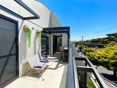 a balcony of a house with two chairs and a table at Oceanic on Thompson Apartments in Cowes