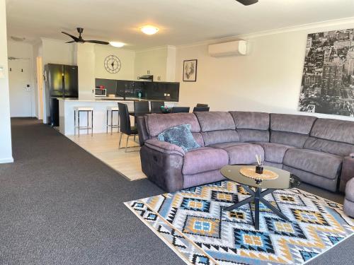 a living room with a purple couch and a kitchen at Oceanic on Thompson Apartments in Cowes