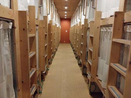 a long aisle of wooden shelves in a library at Cafe&Hostel きみといちご in Osaka