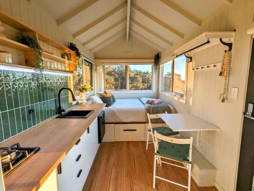a tiny house with a kitchen and a bedroom at Kyneton Tiny House - Tiny Stays in Metcalfe