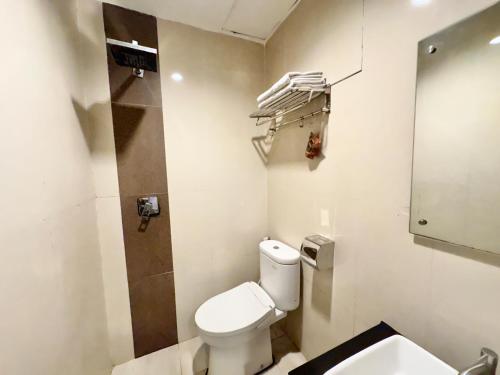 a small bathroom with a toilet and a sink at My Home Hotel Pontianak in Pontianak