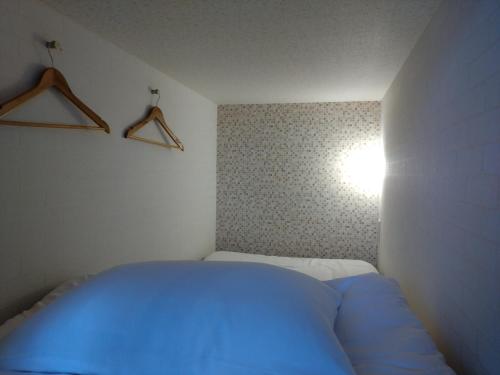 ein Schlafzimmer mit einem blauen Bett in einem Zimmer in der Unterkunft Cafe&Hostel きみといちご in Osaka