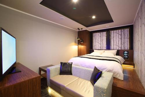 sypialnia z łóżkiem i telewizorem z płaskim ekranem w obiekcie ホテルクリスタルゲート木更津 w mieście Kisarazu