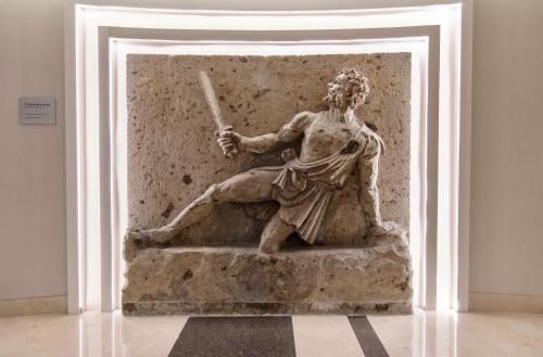a statue of a man holding a bat in a museum at Hotel Plaza Diana in Guadalajara