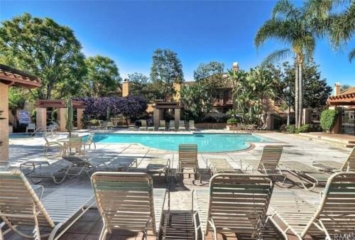 um grupo de cadeiras e uma piscina em 3 bedroom modern home with pool area at the Tustin Marketplace -15 minutes to Disneyland em Tustin