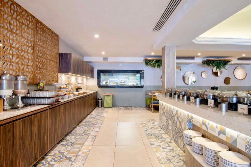 a restaurant with a counter with dishes on it at Hotel Plaza Diana in Guadalajara