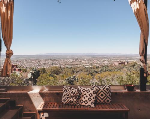 a bench sitting on a ledge with a view of a city at Cuna del Cielo in San Miguel de Allende