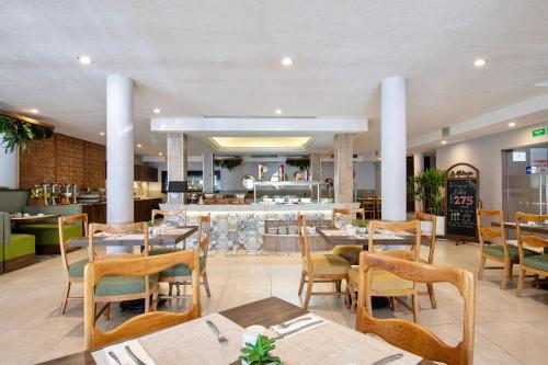 a restaurant with tables and chairs and a bar at Hotel Plaza Diana in Guadalajara