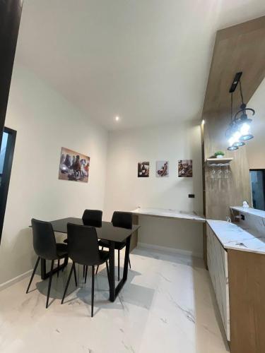 a dining room with a black table and chairs at SS Home in Ban Don Wai
