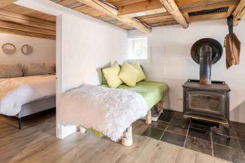 a bedroom with a bed and a wood stove at Chalet L’Oasis Zen in Nominingue