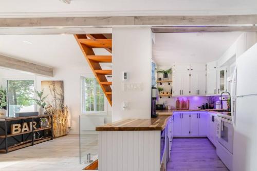 a kitchen with white cabinets and purple counters at Chalet L’Oasis Zen in Nominingue