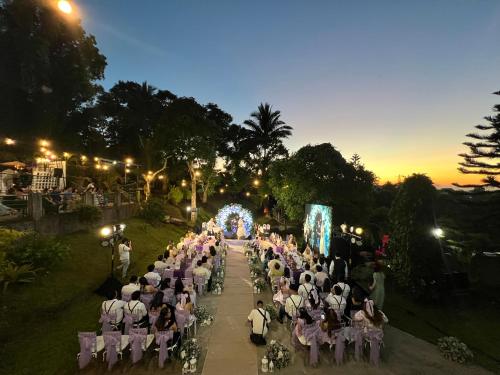 een groep mensen die in stoelen zitten op een bruiloft bij MC Mountain Home in Tagaytay