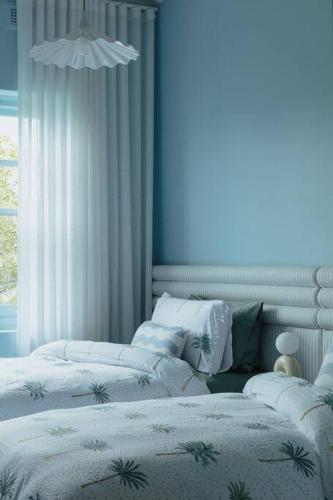 a bedroom with three beds and a window at Tender is the Stay - Luxury designer 2BR Glenelg in Glenelg