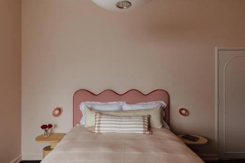 a bed with a pink headboard in a bedroom at Tender is the Stay - Luxury designer 2BR Glenelg in Glenelg