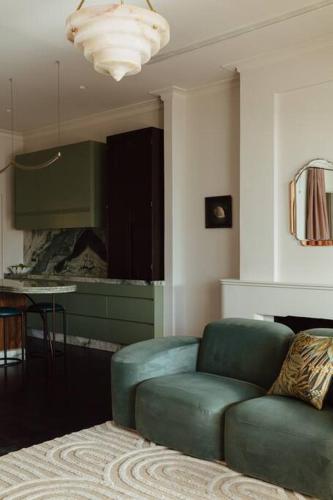 a living room with a blue chair and a table at Tender is the Stay - Luxury designer 2BR Glenelg in Glenelg