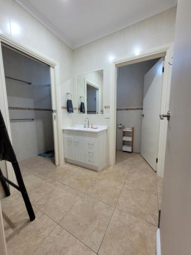 uma casa de banho com um lavatório e um espelho em Sunshine House - Abnb 