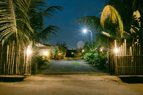 a street with palm trees and street lights at night at Sriwedari House Keramas in Gianyar