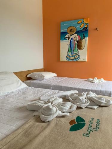 duas camas com sapatos brancos no chão num quarto em Pousada Bugaendrus em Touros
