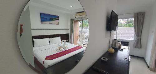 a reflection of a bedroom with a bed in a mirror at At Home Hotel in Patong Beach