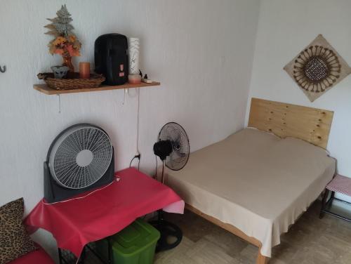 - une chambre avec un lit, un ventilateur et une chaise dans l'établissement Beach Cat 3, à Cancún