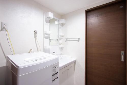 ein Badezimmer mit einem Waschbecken und einer Waschmaschine in der Unterkunft Hotel Fu-Rin in Fukuoka