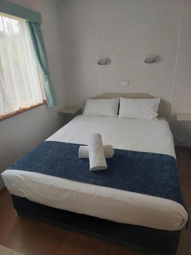 a bed with a towel on it in a bedroom at Casuarina Cabins in Nelson