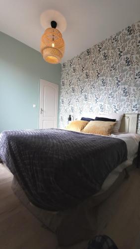 a bedroom with a large bed with a patterned wall at Gite Urbain - La Capsule - Parking in Épernay