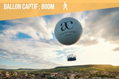 a hot air balloon flying over a city at Gite Urbain - La Capsule - Parking in Épernay