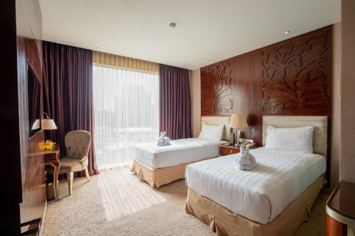 Cette chambre comprend 2 lits et une fenêtre. dans l'établissement Belviu Hotel Bandung, à Bandung