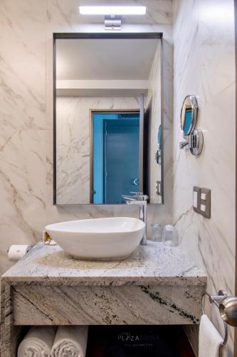 a bathroom with a sink and a large mirror at Hotel Plaza Diana in Guadalajara