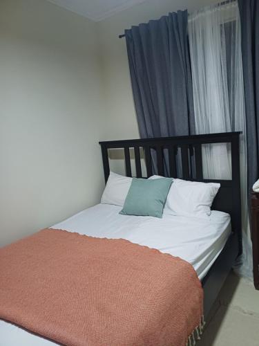 a bedroom with a bed with a orange blanket on it at Bello Apartamento, 2 habitaciones 2 baños Santo Domingo Carmen Renata III in Santo Domingo