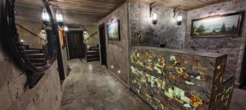 a hallway with a stone wall with mosaic tiles at konak esila in Uşak