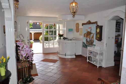 a living room with a kitchen with a tile floor at Inselhotel Arfsten in Wyk auf Föhr