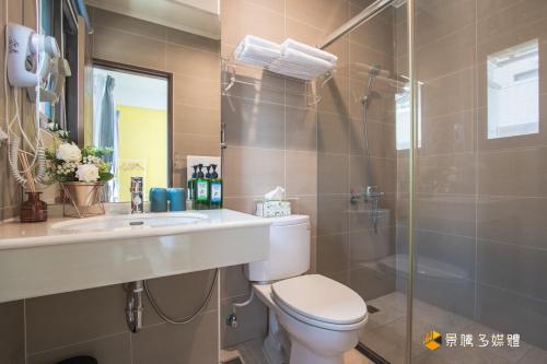 a bathroom with a toilet and a sink and a shower at Sunny No85 B&B in Toucheng