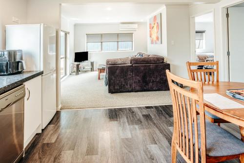 a kitchen and living room with a table and a bed at Sunrise Accommodation in Whakatane