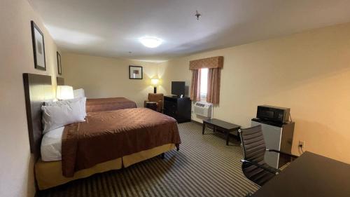 um quarto de hotel com uma cama e uma secretária em Whitney Inn & Suites em Hamden