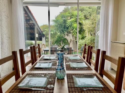 - une table à manger avec un vase en verre dans l'établissement Spacieuse maison 6 pers à Sète - WIFI, animaux bienvenus, parking, clim mobile - FR-1-338-4, à Sète