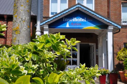 a building with a sign on the front of it at Inselhotel Arfsten in Wyk auf Föhr